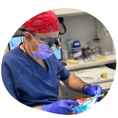 Gum care: a dental professional wearing loupes works with dental instruments