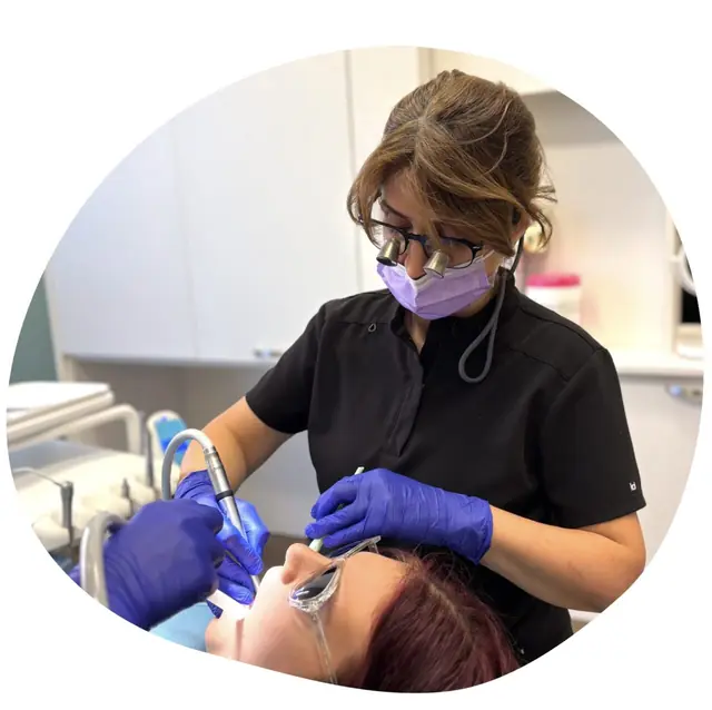 General dentistry: a dental professional wearing loupes examines a patient’s mouth
